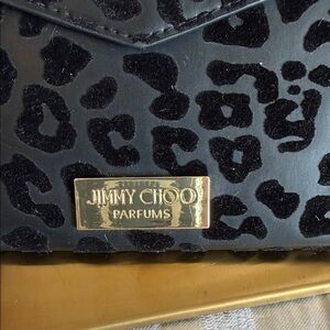 Cosmetic Jommy Choo bag. 10 by 5 1/2 insppx Black embossed